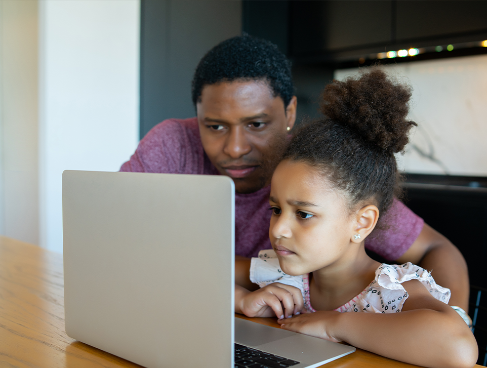 Father helping child on laptop